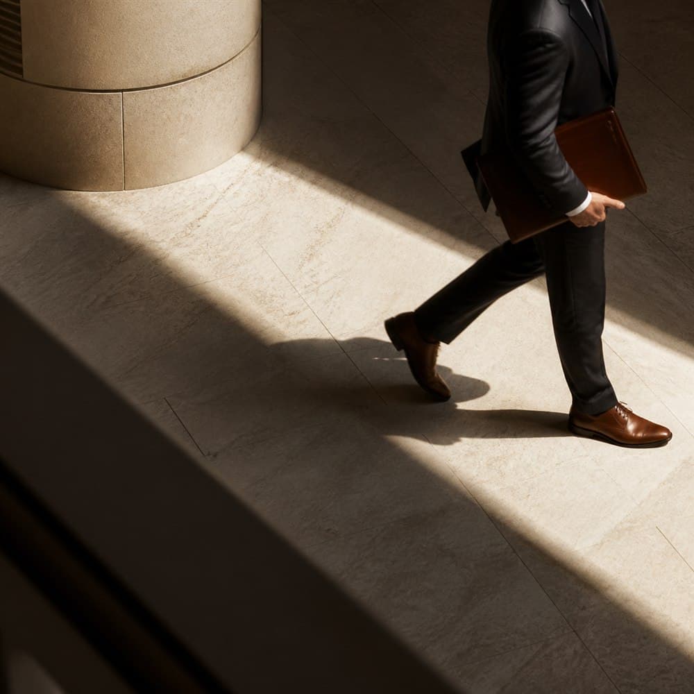 Investment professional crossing a light-filled stone lobby